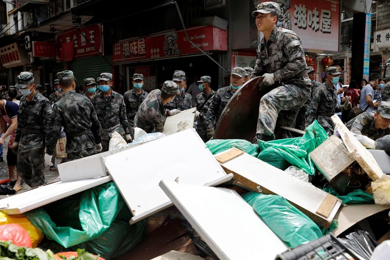 台風13号の被害によるがれきを撤去する中国人民解放軍の兵士たち=マカオで25日、ロイター