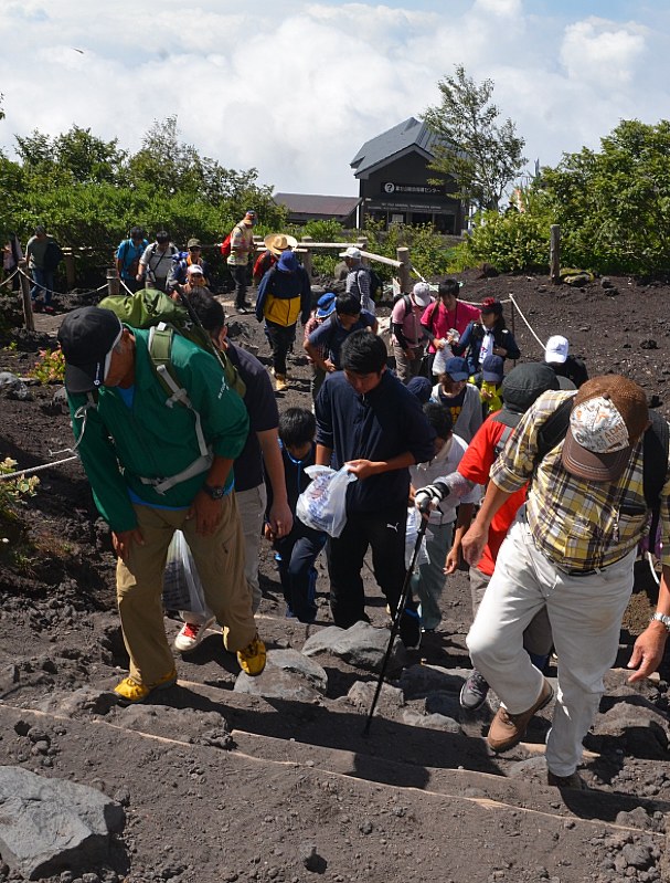 ごみ袋を持ち登山道を登る参加者ら=富士山の富士宮口5~6合目で
