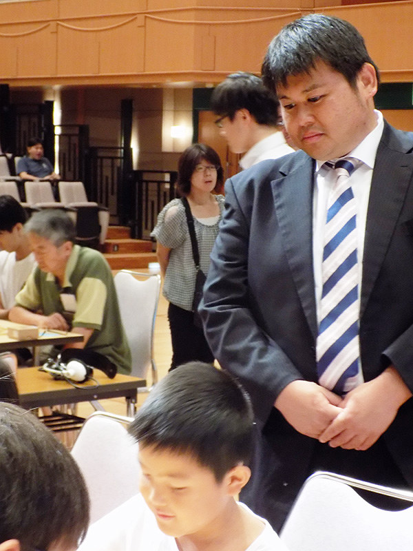 将棋大会で子どもたちの対局を見守る阪口悟五段=大阪市高石市のアプラ高石で、新土居仁昌撮影