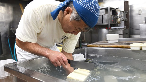 できあがった豆腐を丁寧にカットする