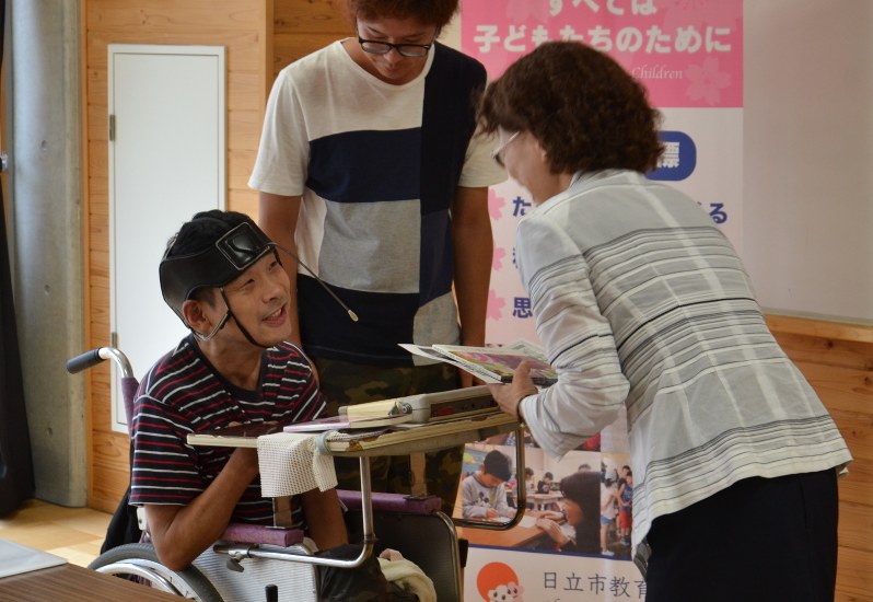 絵本を日立市内の小中学校に贈った藤枝さん(左端)=同市鹿島町3の助川中学校で
