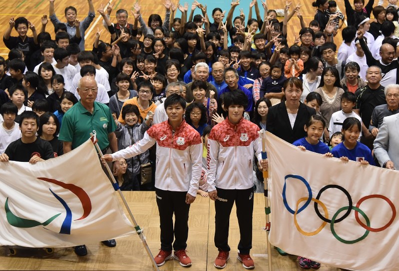市民とともに五輪旗・パラリンピック旗を掲げる加藤(中央右)、山室(同左)両選手ら=草加市で