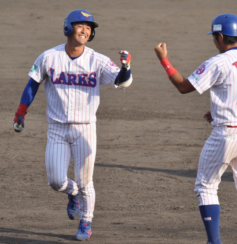 【九州総合スポーツカレッジ-鮮ど市場ゴールデンラークス】延長十回裏ラークス2死二塁、左越えのサヨナラ適時二塁打を放ち、仲間と喜び合う鈴木選手(左)