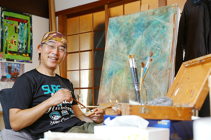 仕事場の一室で、カンバスに向かう作家の吉村萬壱さん=大阪府貝塚市で、菅知美撮影