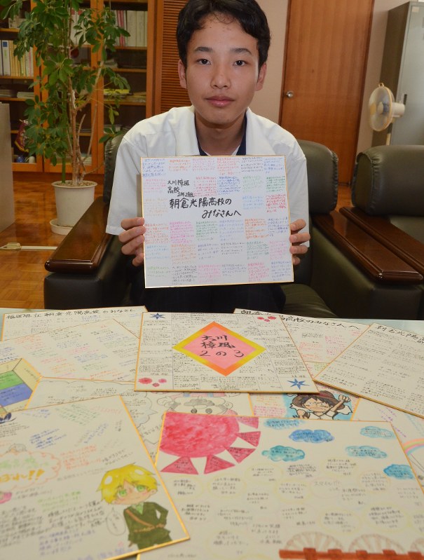 全校生徒が書いた寄せ書きを生徒代表で持参する権藤さん