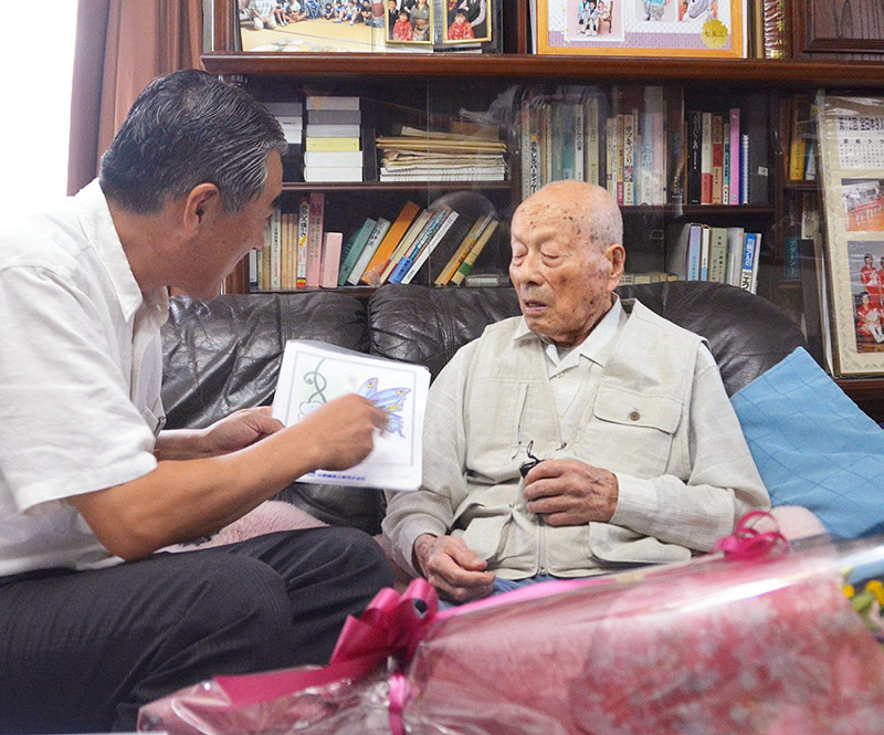 滋賀県彦根市内男性最高齢の尾本捨三さん(右)宅で長寿を祝う大久保彦根市長