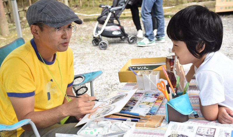 子どもの似顔絵を描く阿部仁文さん(左)=宮城県登米市の柳津虚空蔵尊で2017年9月10日午後0時2分、中川友希撮影