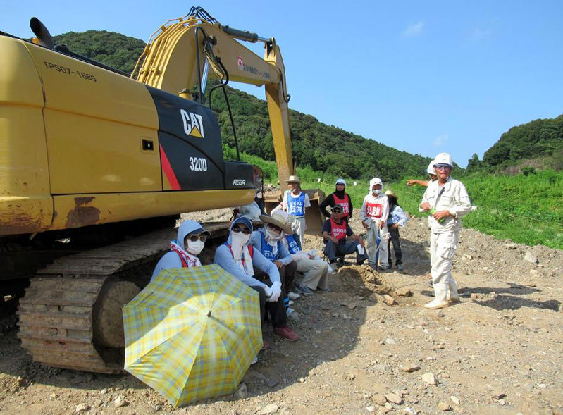 工事現場内の重機の前に座り込んで抗議する地権者ら=支援者提供