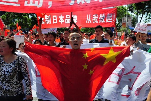 中国国旗を掲げ、日本の尖閣諸島国有化に抗議する反日デモの参加者=2012年9月16日、隅俊之撮影