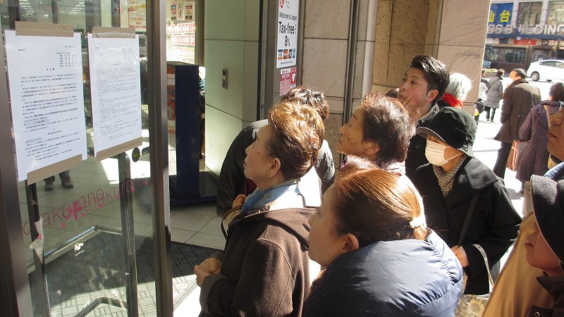 さくら野百貨店仙台店入り口で営業停止を知らせる張り紙を見る買い物客ら=2017年2月27日、鈴木一也撮影