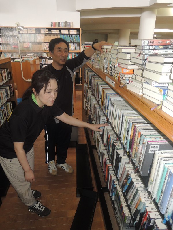棚の上に本を移し、蔵書を守った宗像館長(奥)と山口さん