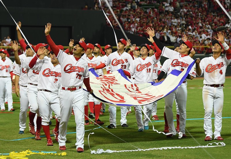 優勝セレモニーでグラウンドを一周し、ファンの声援に応える広島の選手たち=久保玲撮影