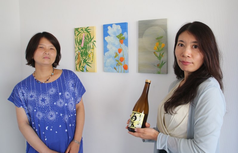 出展アーティストの板垣幸子さん(左)ときき酒師の松井かおりさん=港区で