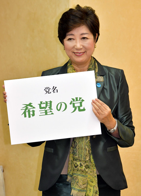 国政政党「希望の党」を設立し代表に就任することを発表した記者会見の終わりに、党名の書かれたボードを持って写真撮影に応じる東京都の小池百合子知事=都庁で2017年9月25日、西本勝撮影