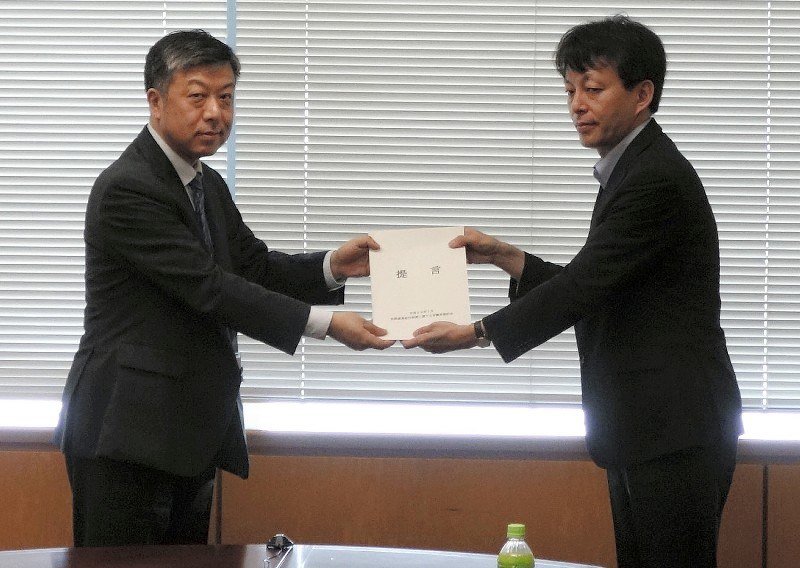 有識者会議の座長を務めた川出敏裕東大大学院教授(右)から提言を受け取る警察庁の西川直哉審議官(当時)=東京都千代田区の警察庁で7月14日、川上晃弘撮影