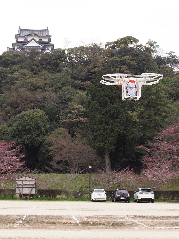 彦根城をバックに飛行する滋賀県彦根市の広報用ドローン=同市金亀町で、西村浩一撮影