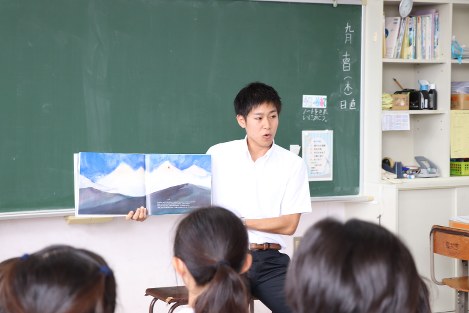 児童に読み聞かせを行う学生＝９月１４日