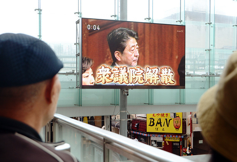 衆院解散を伝える大型テレビを眺める市民=富山市総曲輪3のグランドプラザで、鶴見泰寿撮影