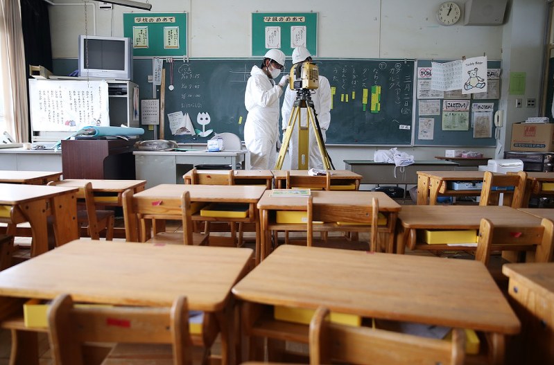 大熊町立大野小学校の教室を3D撮影する測量士ら=福島県大熊町で22日、宮武祐希撮影