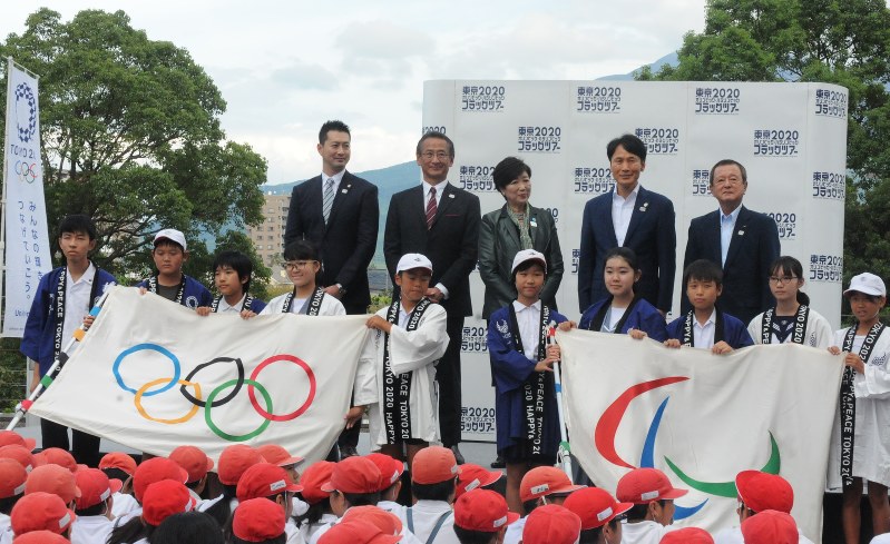 五輪旗、パラリンピック旗を持って記念撮影する関係者ら