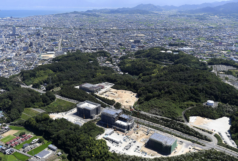 愛媛県今治市の郊外で建設が進む岡山理科大獣医学部の校舎(手前)=2017年8月、本社ヘリから久保玲撮影