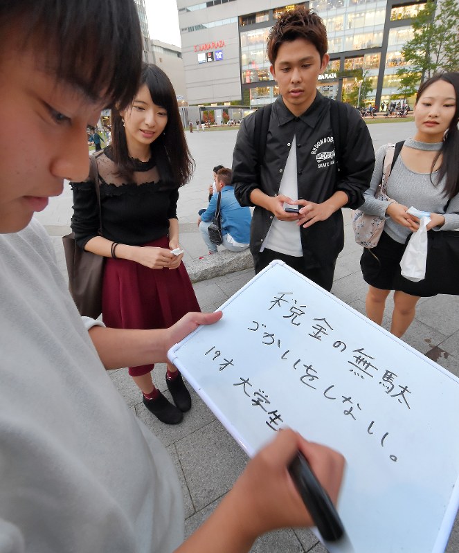 政治家に求めることを若者(手前)に書いてもらう「ドットジェイピー」のメンバーたち=福岡市中央区で2017年10月8日午後5時55分、上入来尚撮影