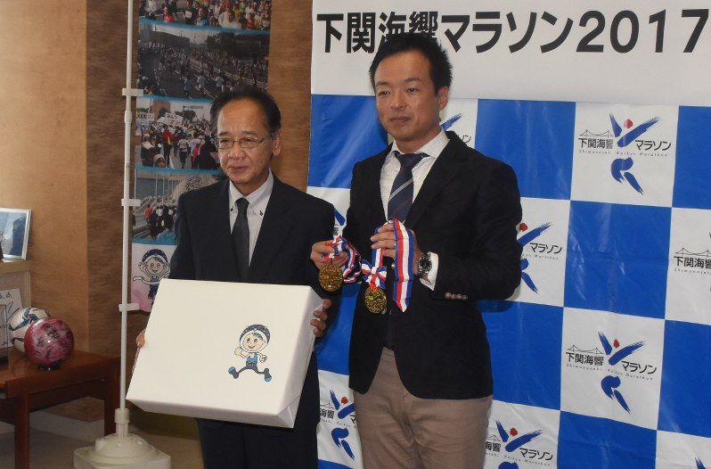 前田市長(右)に金メダルを寄贈した石田理事長