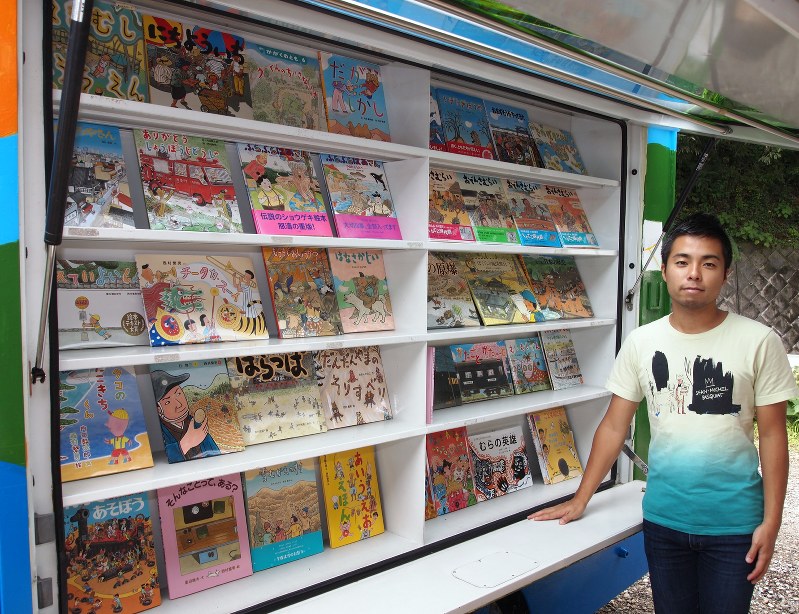 西村さんの絵本を展示した移動図書館車と高濱さん