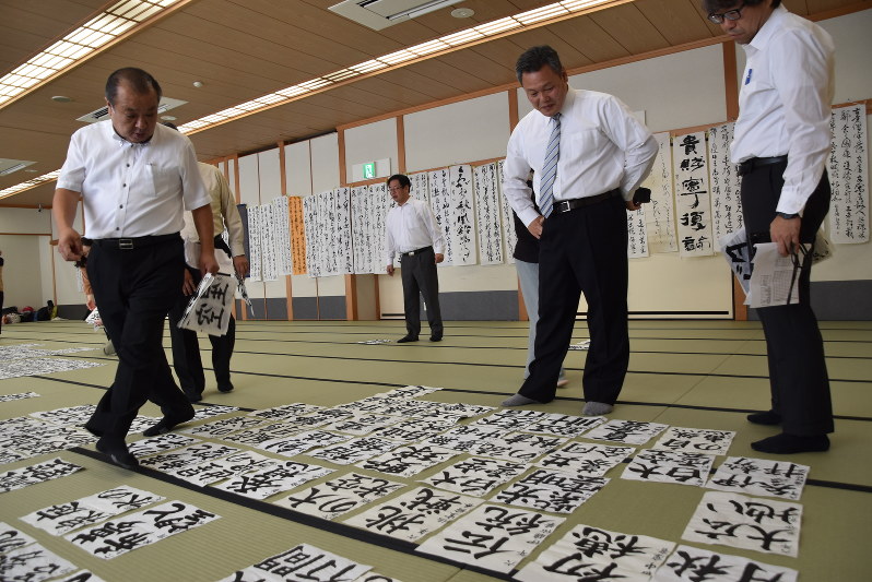神宮会館大広間いっぱいに並べられた予備審査通過作品を審査する書家ら