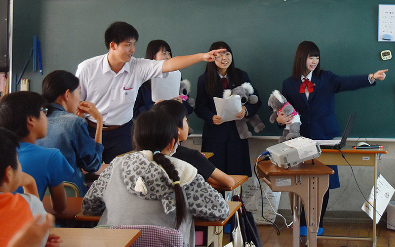 留学体験を披露する名張西・名張青峰高の生徒たち=三重県名張市の百合が丘小で、広瀬晃子撮影