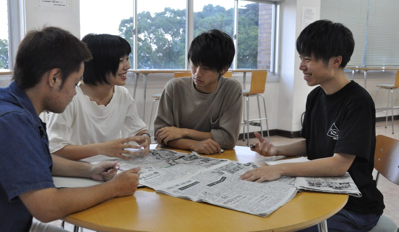 衆院選について新聞を見ながら話し合うドットジェイピーの学生