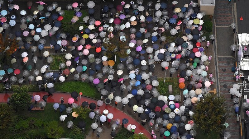 雨が降る中、街頭演説を聞く有権者ら=大阪市内で2017年10月15日午後4時、本社ヘリから加古信志撮影(画像の一部を加工しています)