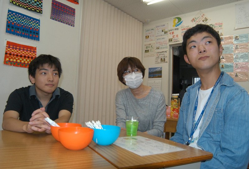 大阪府松原市の自立訓練事業所「ぽぽろスクエア」で打ち合わせをする都築裕介さん(右)と榎木裕也さん(左)ら=山下貴史撮影