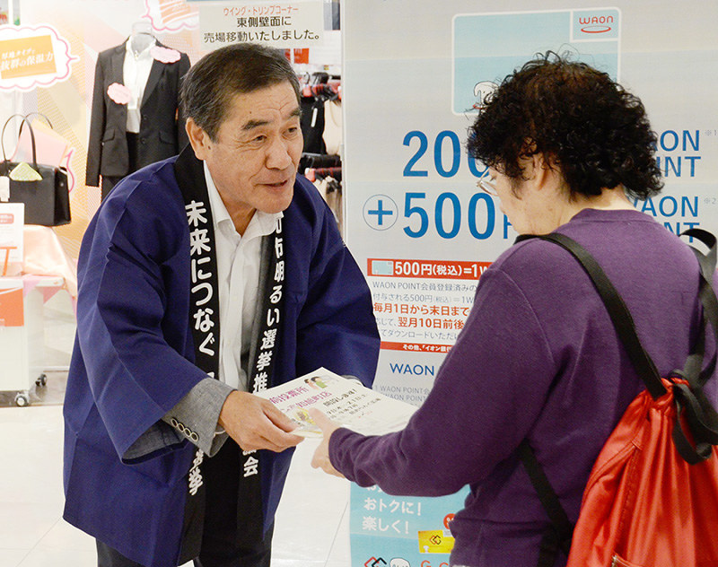 来店者に期日前投票を呼び掛ける高知市選管の職員=高知市旭町で、柴山雄太撮影