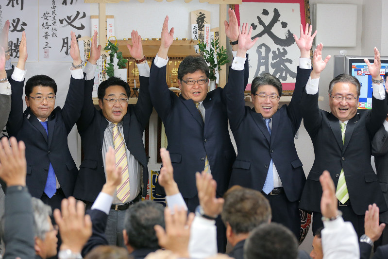当選確実の報を受け、万歳する萩生田光一氏(中央)=八王子市で22日午後8時13分、宮武祐希撮影