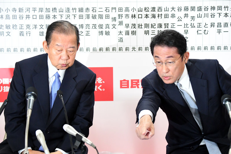 自民党開票センターのモニターで流された選挙速報番組を見る二階俊博幹事長(左)と岸田文雄政調会長=東京都千代田区の党本部で2017年10月22日午後8時7分、川田雅浩撮影