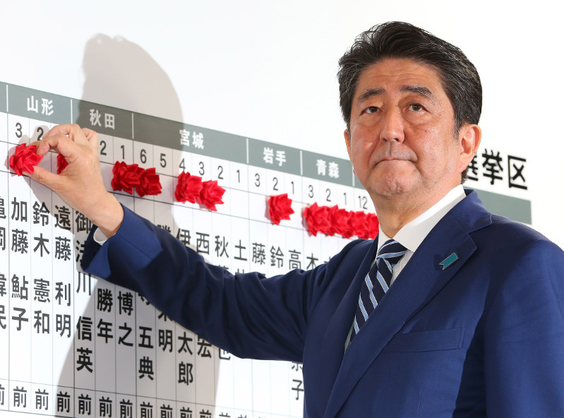 当選確実となった候補者の名前に花をつける安倍晋三首相=東京都千代田区で2017年10月22日午後9時41分、小川昌宏撮影