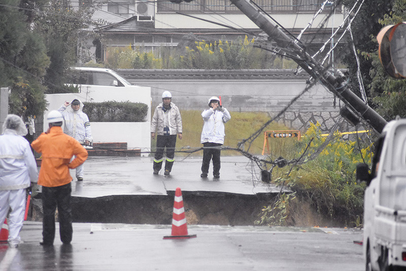 市道が崩落した現場で警戒に当たる警察官ら=滋賀県湖南市岩根で2017年10月22日午後2時15分、衛藤達生撮影