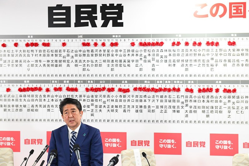 ボードに並ぶ多くの花を背に報道各社のインタビューに答える安倍晋三首相(自民党総裁)=東京都千代田区の党本部で2017年10月22日午後10時41分、川田雅浩撮影