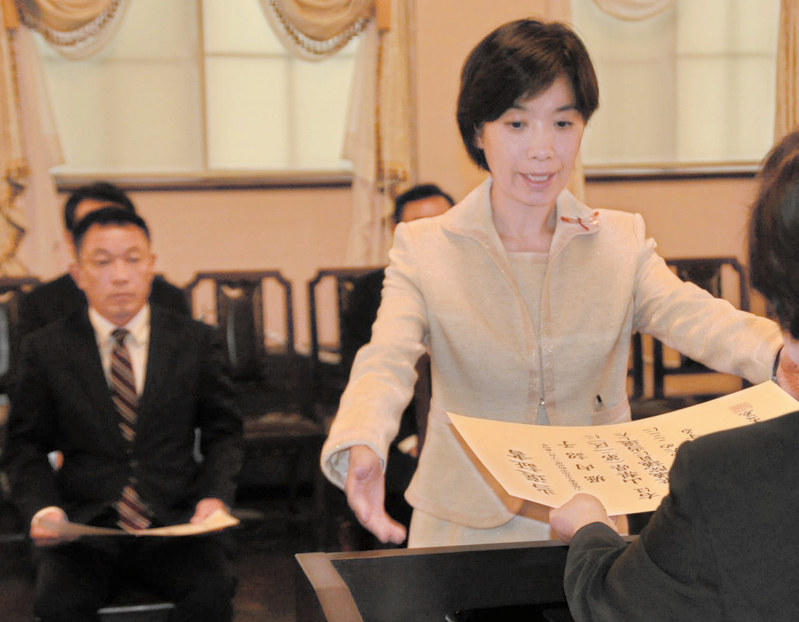 山梨1区の中島克仁氏(左)とともに、当選証書を受け取る山梨2区の堀内詔子氏=甲府市内で2017年10月24日午後1時31分、田中理知撮影