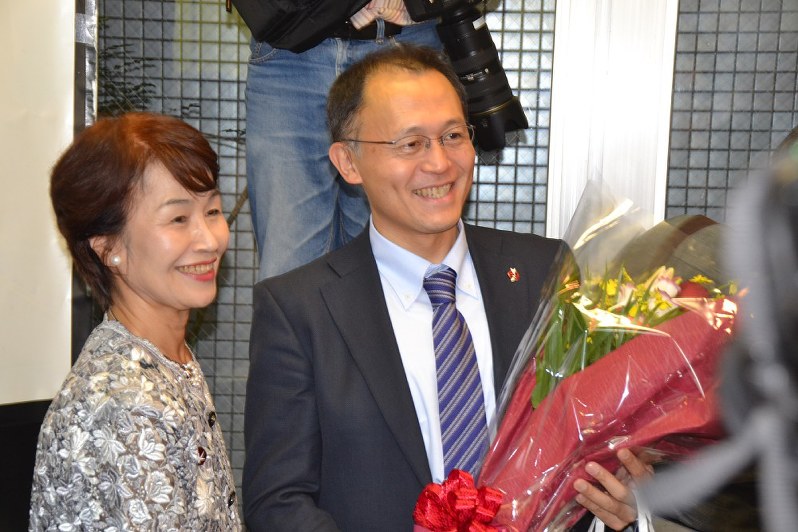 花束を贈られ笑顔を見せる川崎哲さん(右)=東京都新宿区で2017年10月9日午後3時25分、福島祥撮影