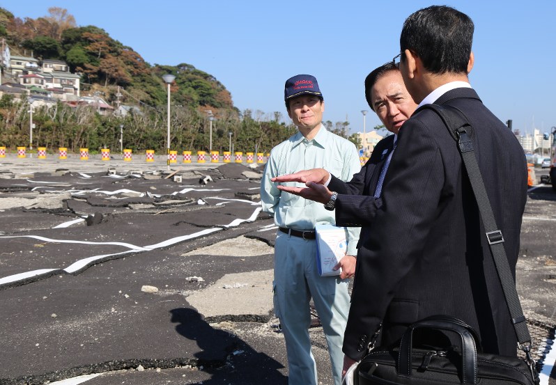 風雨による甚大な被害を受け、アスファルトが波打った状態の駐車場を視察する黒岩知事=藤沢市江の島で