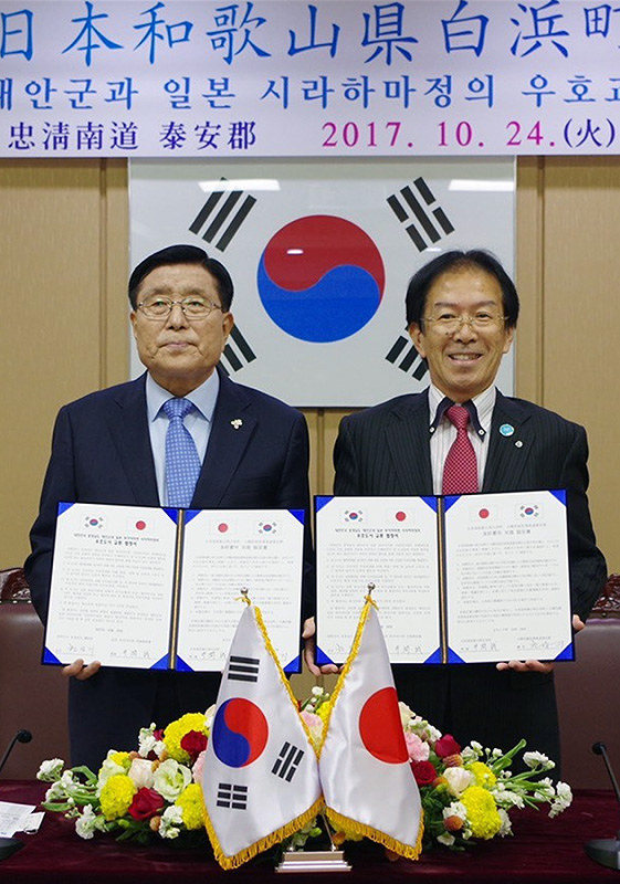 友好都市の交流協定書を手にする和歌山県白浜町の井澗誠町長(右)と韓国・忠清南道泰安郡のハン・サンギ郡守=同郡庁舎で、和歌山県白浜町提供