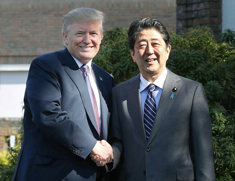 米国のトランプ大統領(左)を出迎え、握手する安倍晋三首相=埼玉県川越市の霞ケ関カンツリー倶楽部で2017年11月5日午後0時7分(代表撮影)