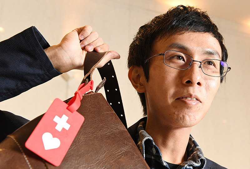 「ヘルプマーク」をかばんに付ける筋ジストロフィー患者の白井祥剛さん=大阪市北区で、大西岳彦撮影