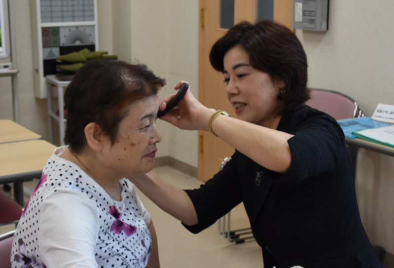 大石華法さん(右)からブラインドメイクを教わる千代元子さん=静岡市葵区で