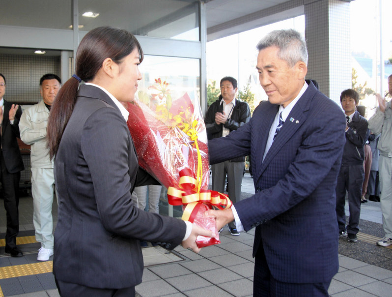 出迎えた職員から花束を受ける兵庫県新温泉町の西村銀三町長(右)=新温泉町役場で2017年11月13日、竹花義憲撮影
