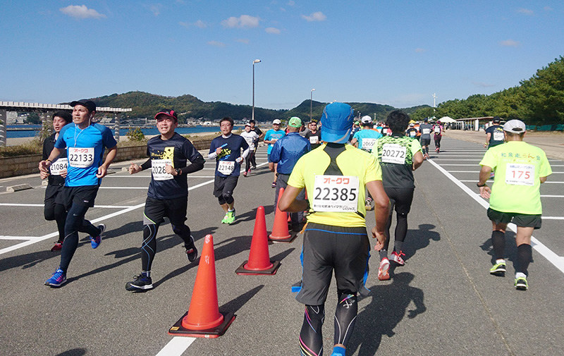 片男波海水浴場沿いのコースを走るハーフのランナーたち=和歌山市で、矢倉健次撮影