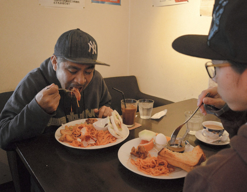 兵庫県姫路市の「オーシャンカフェ」で、「スペシャルモーニング」をおいしそうに食べる同市の男性(40)=左。昼食もこの後、しっかり食べるという。健康状態は良好だ。右は通常のモーニングを食べる妻(30)。女性で「スペジャル」を食べる人も多いという=姫路市飾磨区今在家で、2017年11月5日、斎藤義彦撮影