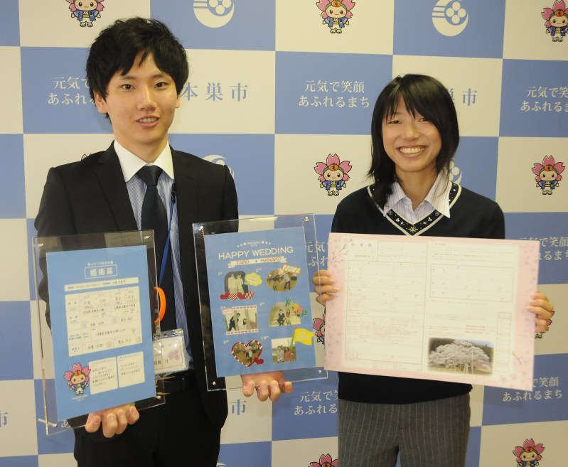 本巣市独自のオリジナル婚姻届(右)とフレームを紹介する市職員=同市役所で